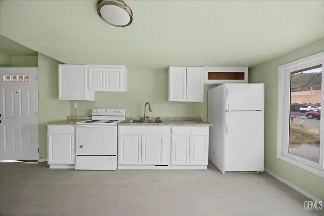 a kitchen with cabinets and a refrigerator