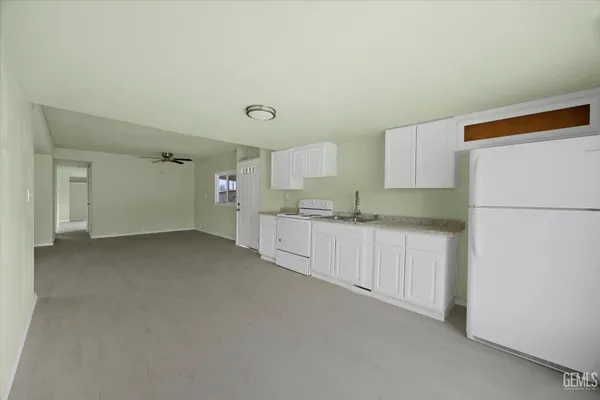 a kitchen with refrigerator and white cabinets