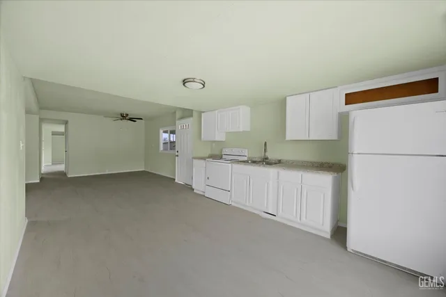 a kitchen with refrigerator and white cabinets