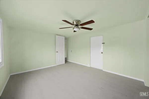 an empty room with a window and a ceiling fan