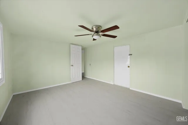 an empty room with a window and a ceiling fan