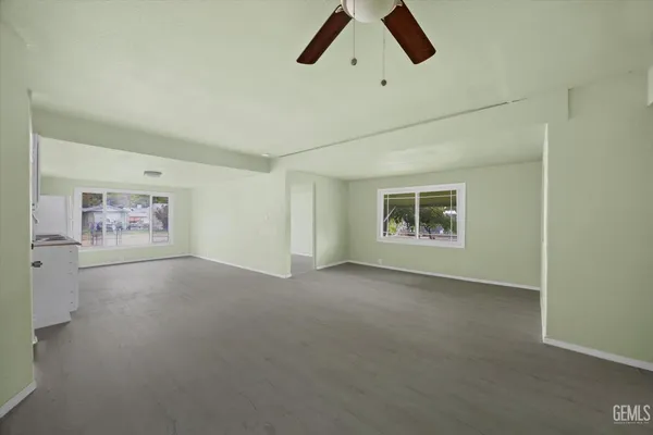 an empty room with painting and windows