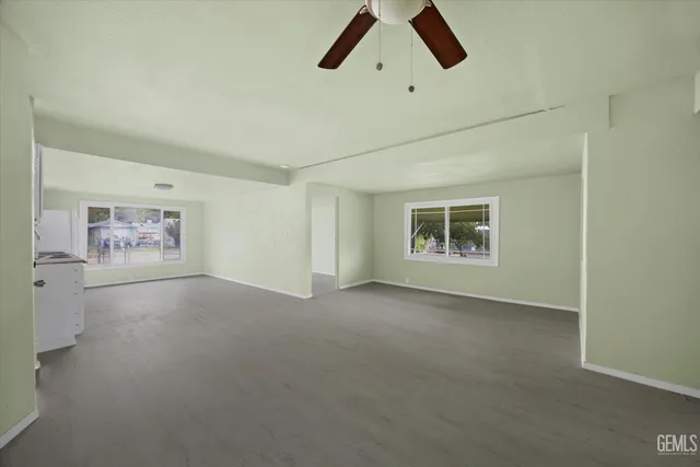 an empty room with painting and windows