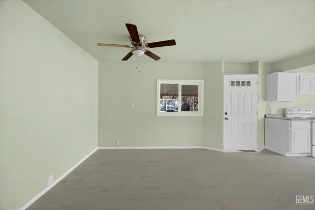 a view of a livingroom with a ceiling fan & a window