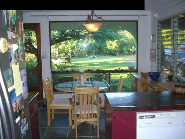 151 Kahiapo Place Haiku, HI 96708 - Photo 3 of 13 a kitchen view with a dining table chairs and floor to ceiling window with yard