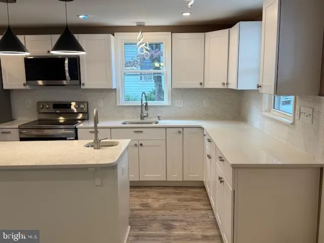 a kitchen with kitchen island a sink stainless steel appliances and cabinets