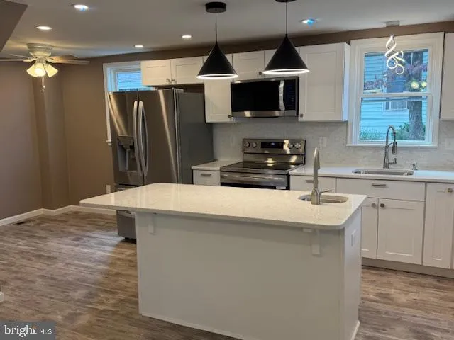 a kitchen with stainless steel appliances a refrigerator and a stove top oven