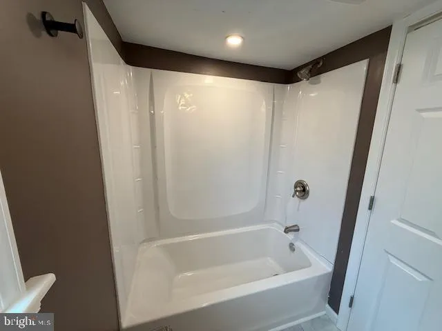 a white toilet sitting next to a bathroom sink and a window