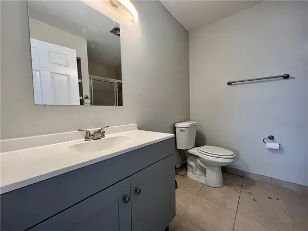 a bathroom with a toilet a sink and mirror