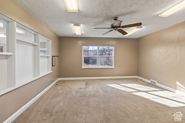 465 North Main Street Richfield, UT 84701 - Photo 29 of 43 Carpeted spare room featuring ceiling fan, baseboards, visible vents, and a textured ceiling