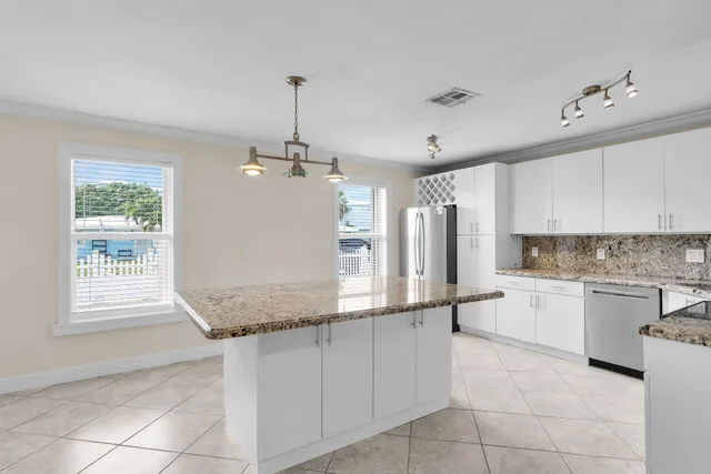 a large kitchen with kitchen island granite countertop a sink window and stainless steel appliances