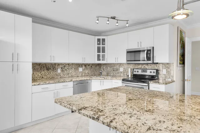 a kitchen with granite countertop a stove sink and microwave