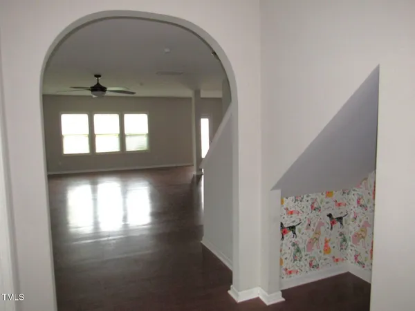 an empty room with wooden floor and windows