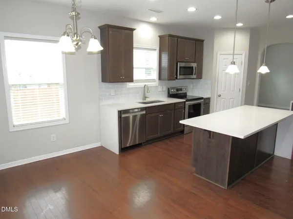 a kitchen with stainless steel appliances a sink a stove a refrigerator and cabinets