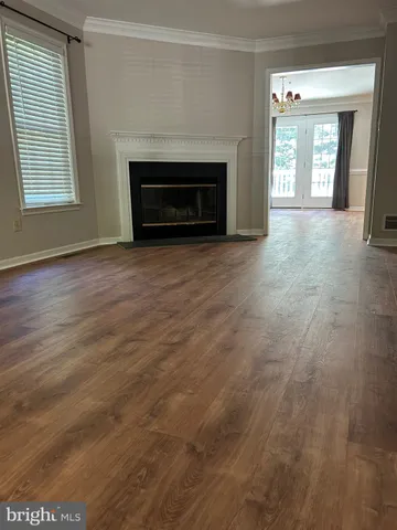 a view of an empty room with a fireplace and a window