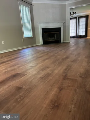 an empty room with windows and fireplace