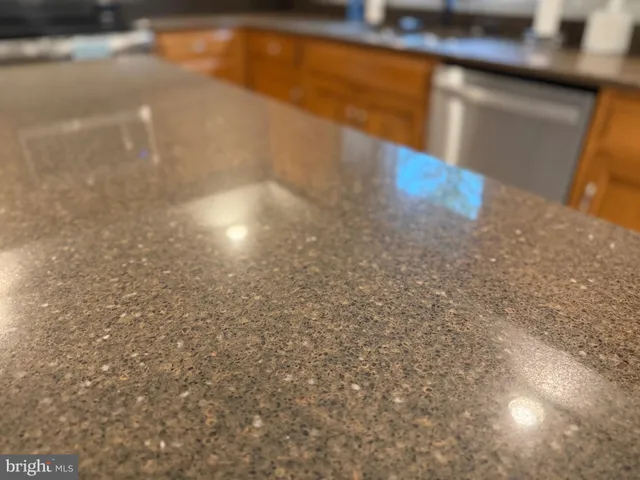 a kitchen with stainless steel appliances granite countertop a refrigerator a stove and a sink with wooden floor