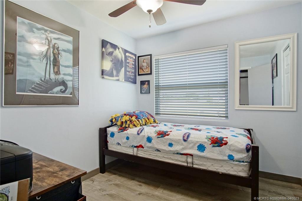 2409 Elizabeth Avenue Fort Pierce, FL 34981 - Photo 13 of 30 a bedroom with a bed and a chandelier