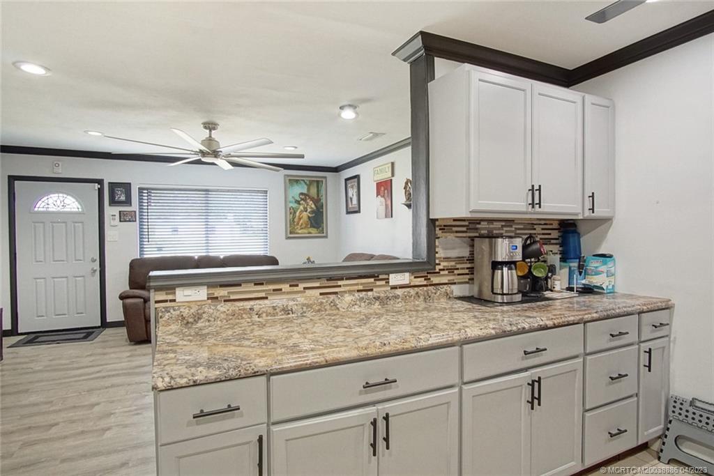 2409 Elizabeth Avenue Fort Pierce, FL 34981 - Photo 5 of 30 a kitchen with granite countertop a sink and white cabinets