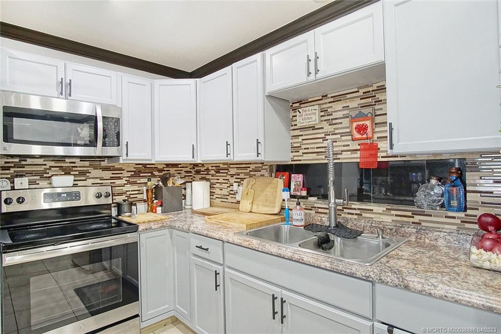 2409 Elizabeth Avenue Fort Pierce, FL 34981 - Photo 6 of 30 a kitchen with stainless steel appliances granite countertop a sink stove and microwave