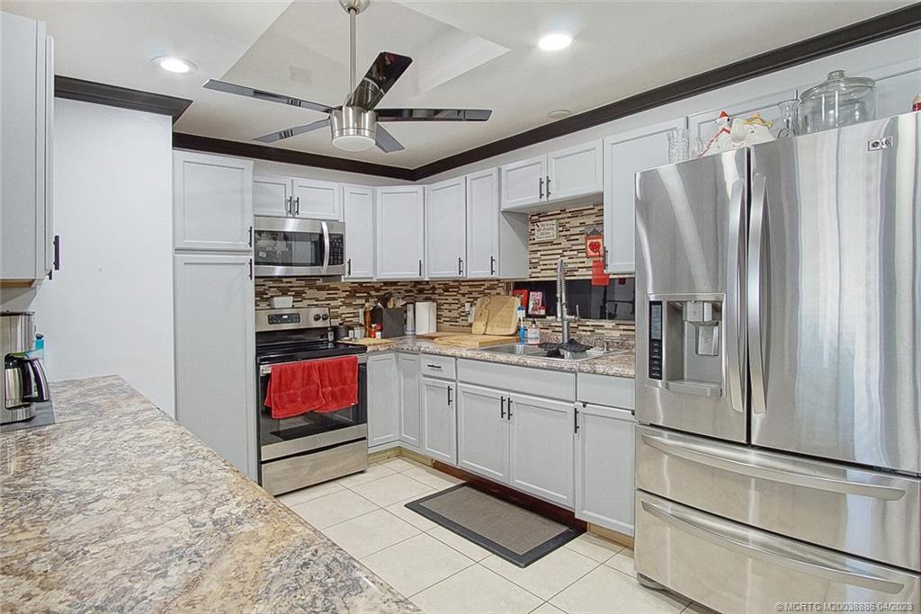 2409 Elizabeth Avenue Fort Pierce, FL 34981 - Photo 7 of 30 a kitchen with stainless steel appliances granite countertop a refrigerator sink and stove