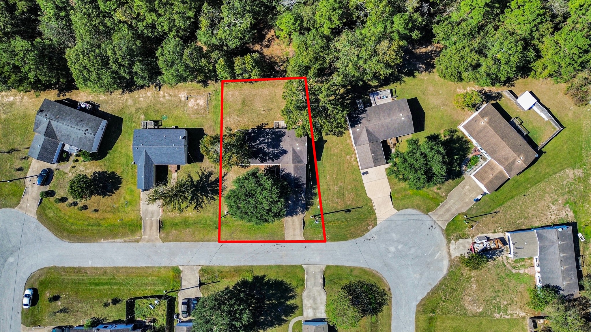 an aerial view of a house with a yard and large tree