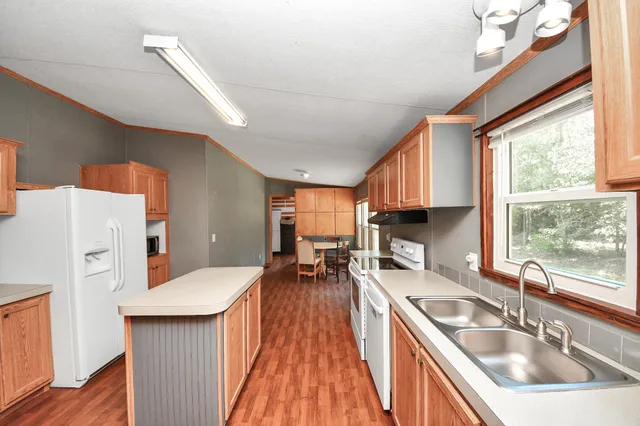 a kitchen with stainless steel appliances granite countertop a sink stove and wooden floor