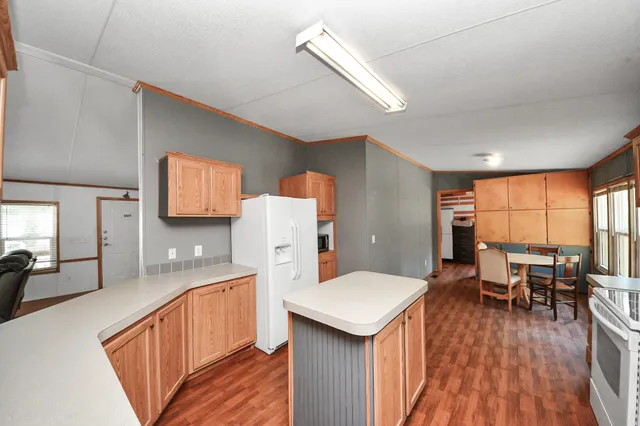 a kitchen with a sink a stove cabinets and wooden floor
