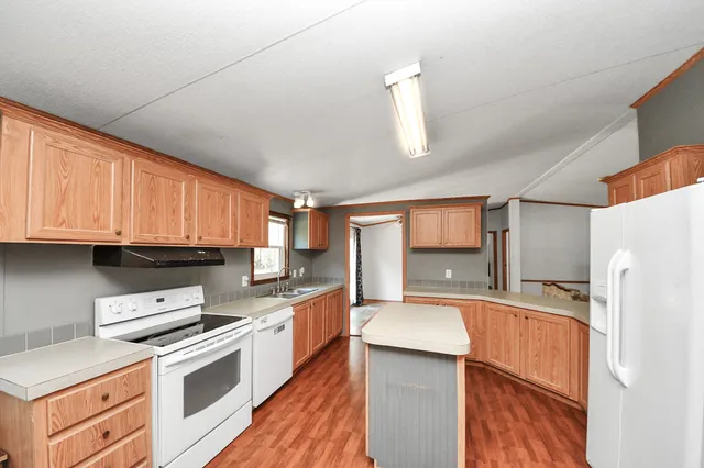 a kitchen that has a sink a stove a refrigerator and a stove top oven