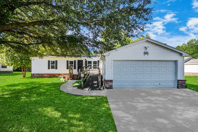 a view of a house with backyard and a tree