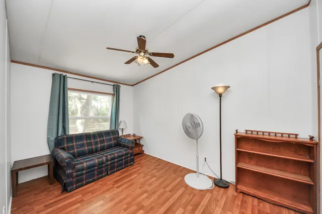 a view of a livingroom with a hardwood floor and a ceiling fan