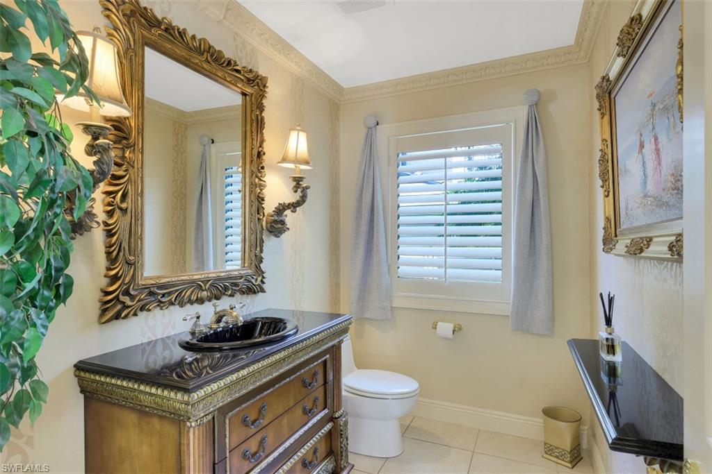 856 Inlet Drive Marco Island, FL 34145 - Photo 12 of 35 a bathroom with a sink a toilet a mirror and window