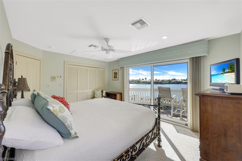 856 Inlet Drive Marco Island, FL 34145 - Photo 17 of 35 a bedroom with a bed and a flat tv screen on the dresser