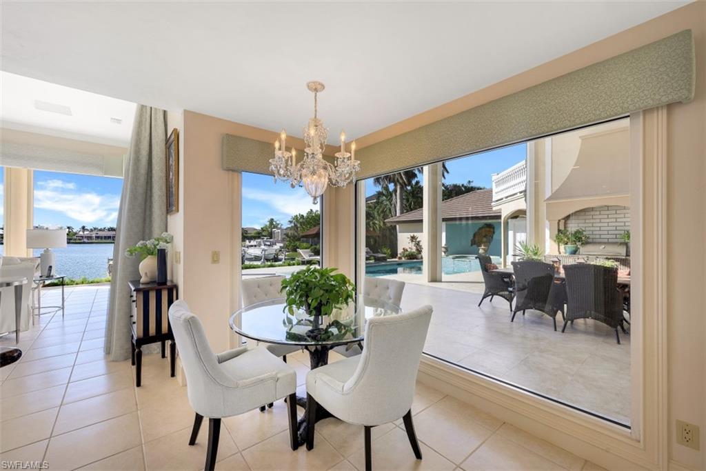 856 Inlet Drive Marco Island, FL 34145 - Photo 9 of 35 a dining room with furniture a chandelier and wooden floor