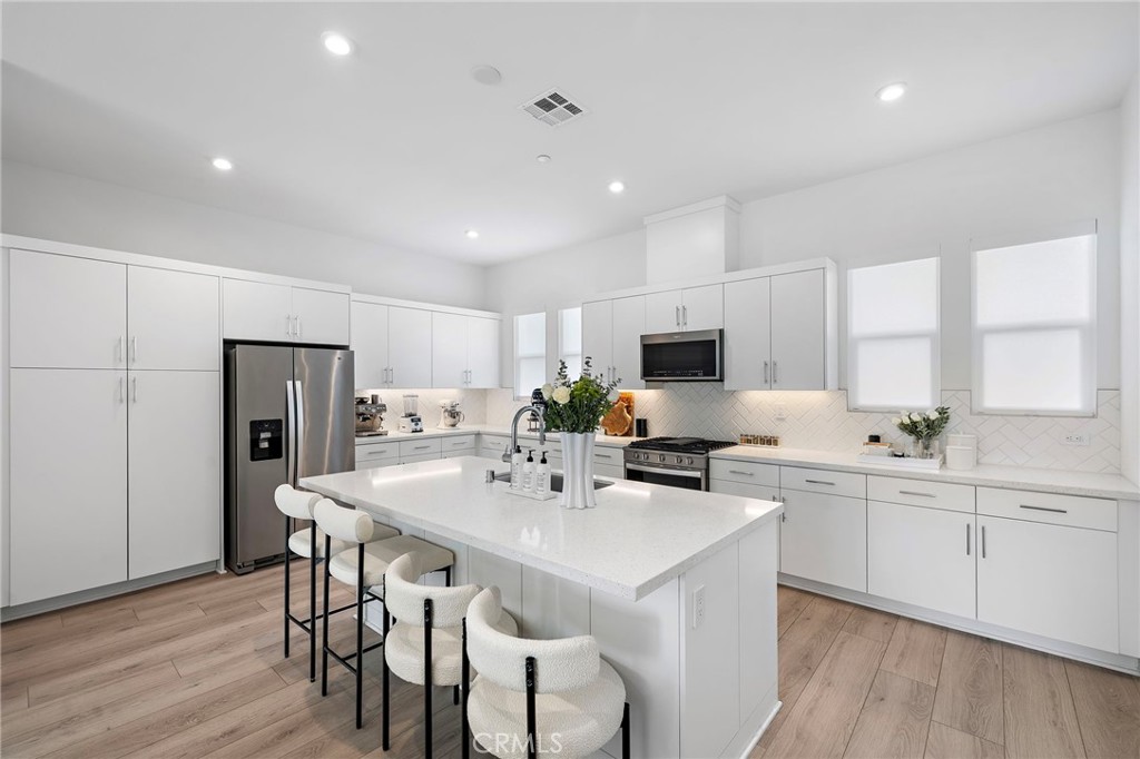 1826 West Bushell Street Anaheim, CA 92805 - Photo 11 of 30 a kitchen with a sink stools a counter space and cabinets