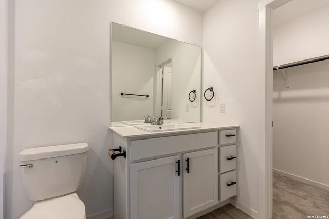 a bathroom with a toilet a sink and mirror