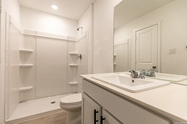 a bathroom with a sink a toilet and shower