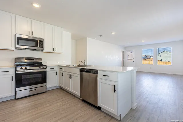 a kitchen with stainless steel appliances granite countertop a stove a sink and a microwave