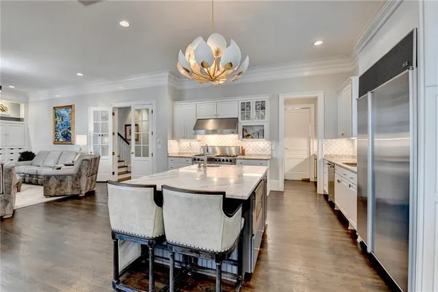 a kitchen with granite countertop white cabinets and stainless steel appliances