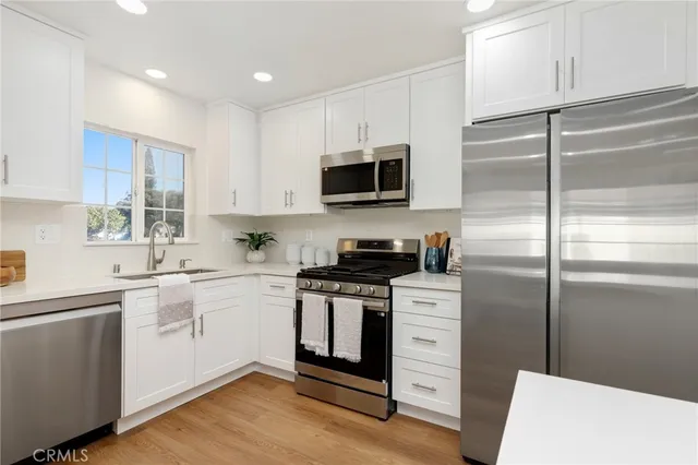 a kitchen with stainless steel appliances granite countertop a sink a stove a microwave and wooden cabinets