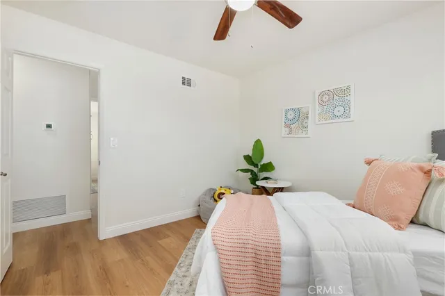 a spacious bedroom with a bed and a ceiling fan