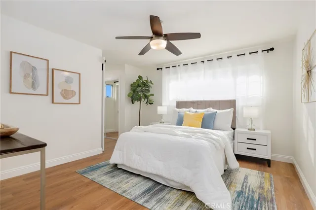 a bedroom with a bed a mirror and a potted plant
