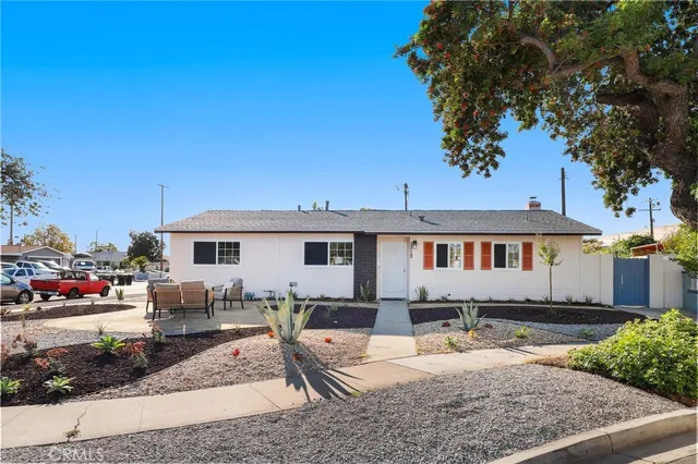 a view of a house with backyard and sitting area