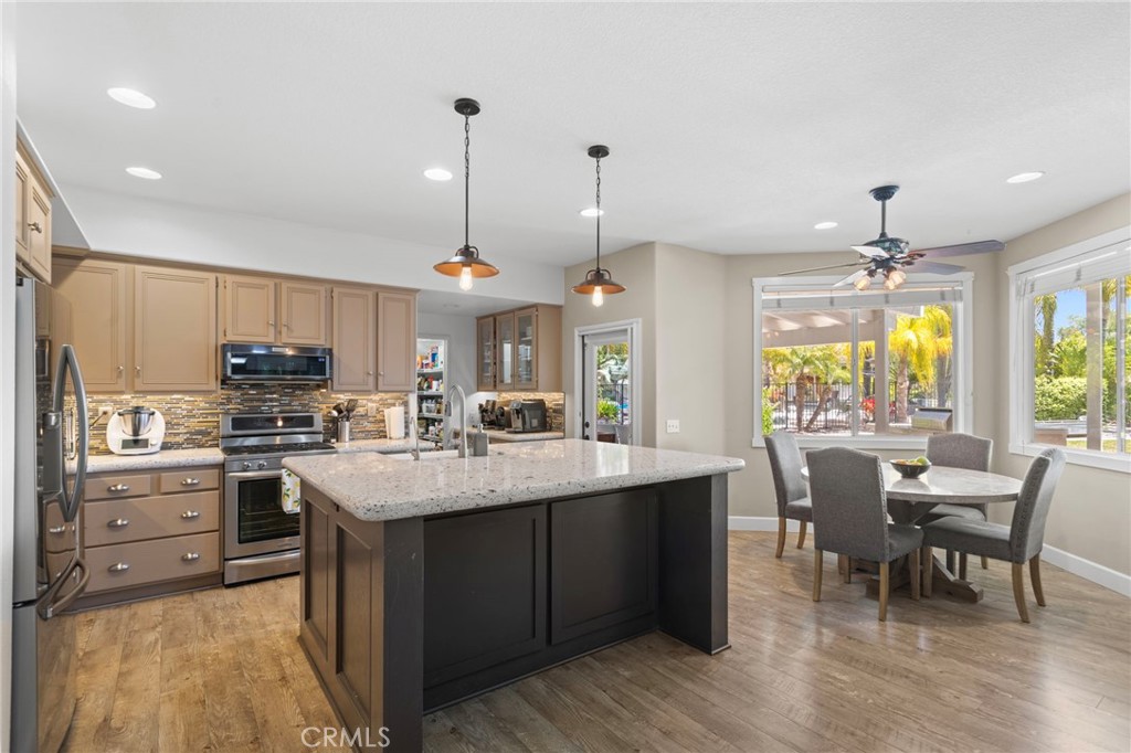 31500 Britton Circle Temecula, CA 92591 - Photo 13 of 44 a kitchen with kitchen island granite countertop a sink stove and refrigerator