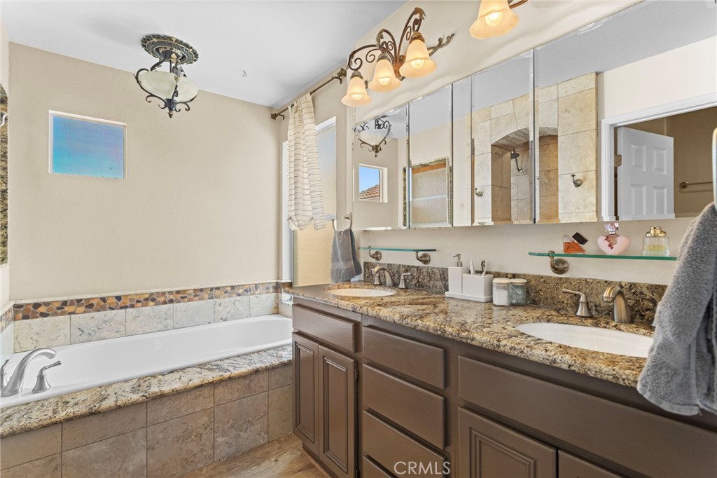 31500 Britton Circle Temecula, CA 92591 - Photo 26 of 44 a bathroom with a granite countertop bathtub a sink and mirror