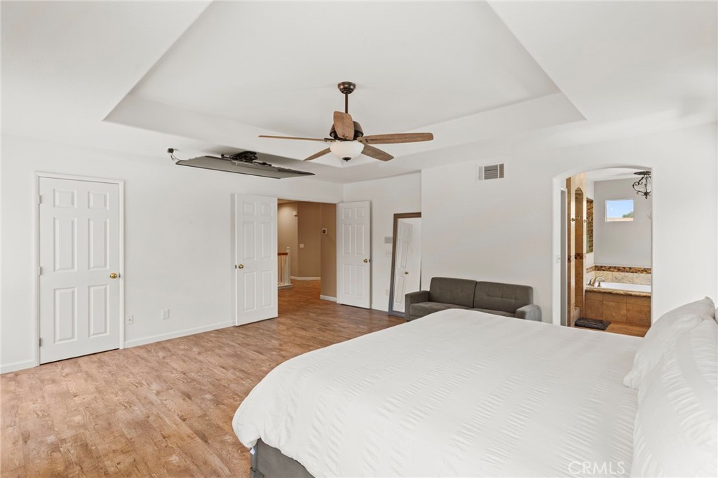 31500 Britton Circle Temecula, CA 92591 - Photo 27 of 44 a bedroom with a large bed and chandelier