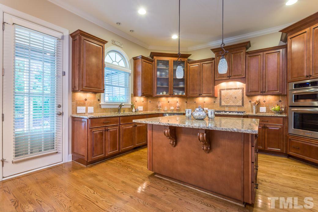 1908 Falls Farm Crossing Raleigh, NC 27614 - Photo 25 of 25 a kitchen with stainless steel appliances granite countertop a sink a stove and a wooden floors