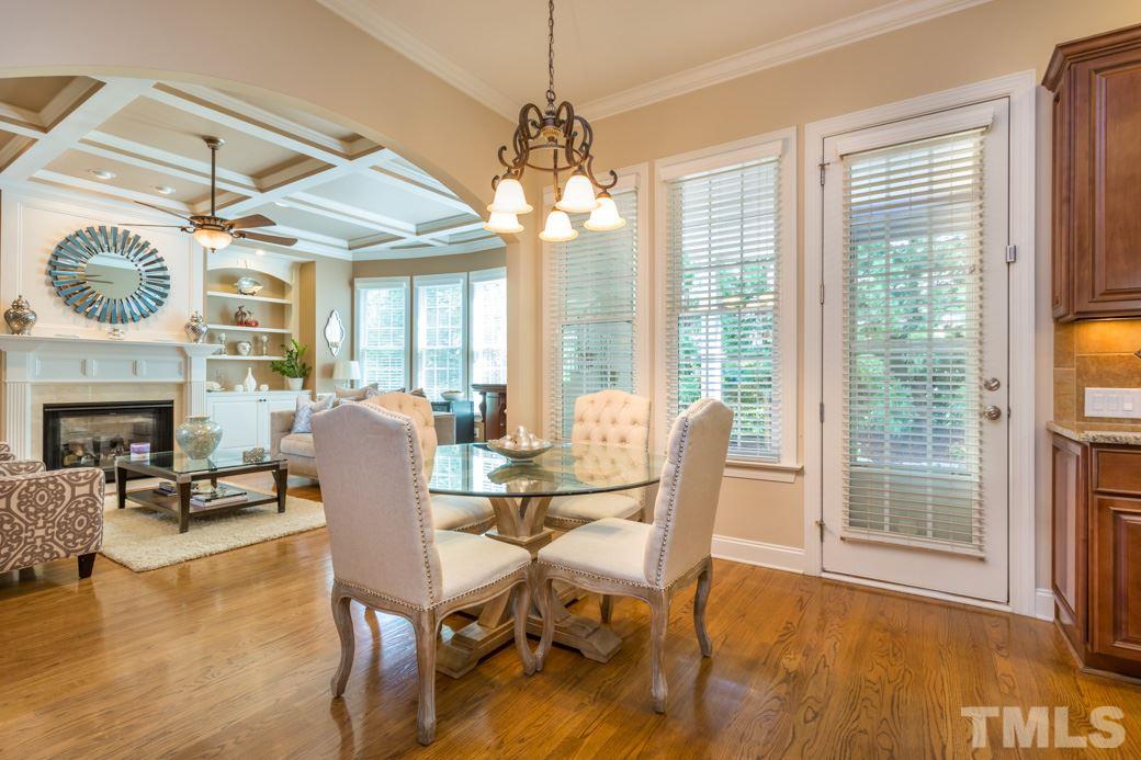 1908 Falls Farm Crossing Raleigh, NC 27614 - Photo 8 of 25 a dining room with furniture a fireplace and large windows