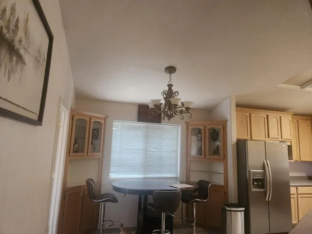 a view of a dining room with furniture and a chandelier