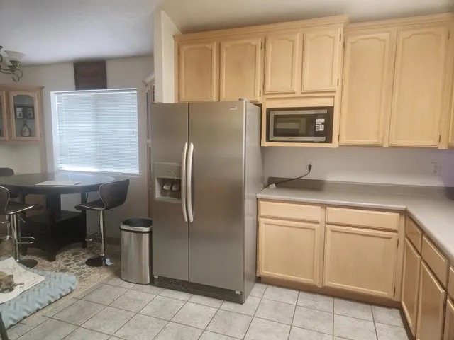 a kitchen with stainless steel appliances granite countertop a refrigerator microwave and sink